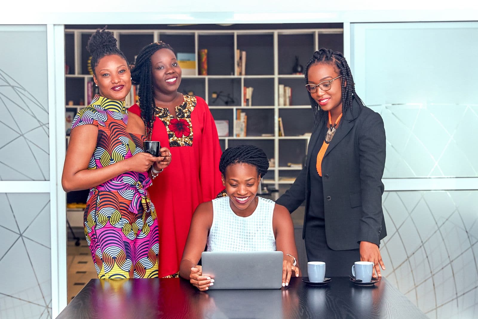 A group of women collaborating around a laptop